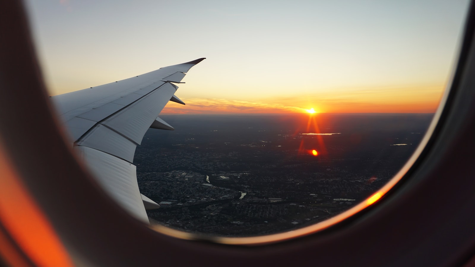 View from an aircraft window over a city at dusk